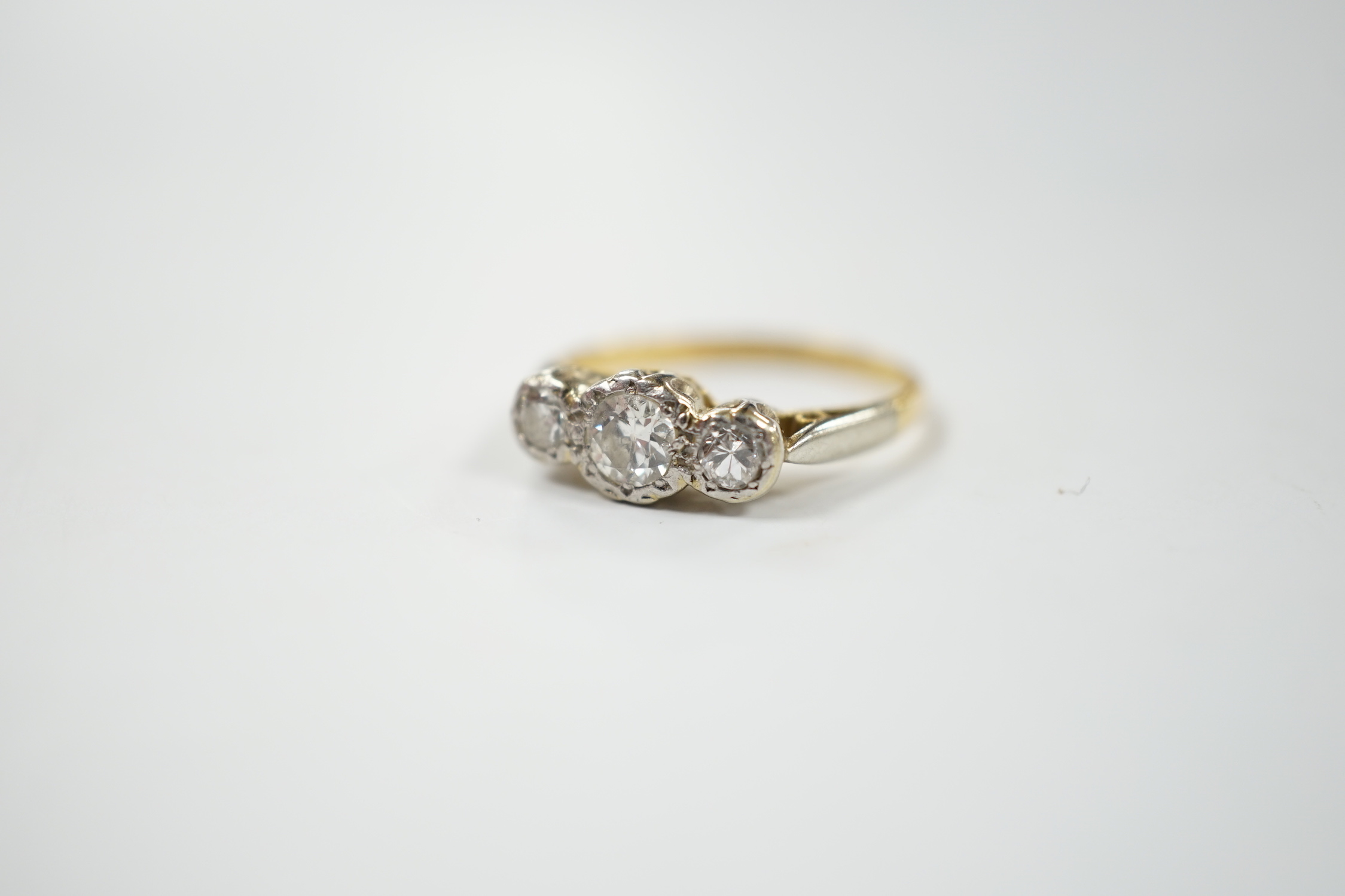 An 18ct, plat and illusion set three stone diamond ring, size J/K, gross weight 2.6 grams.